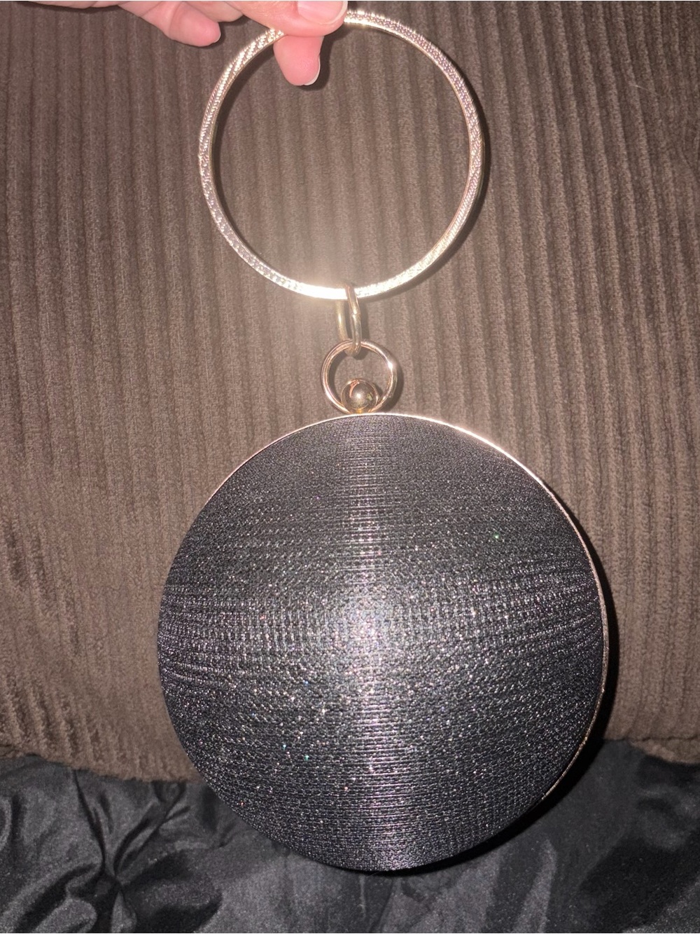 New round spherical evening bag with clasp closure. Black with gold hardware.